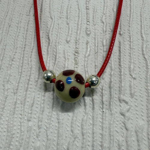 SALE Cream Glass Ball with Blue/Red on Red Cord