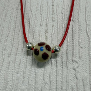 SALE Cream Glass Ball with Blue/Red on Red Cord